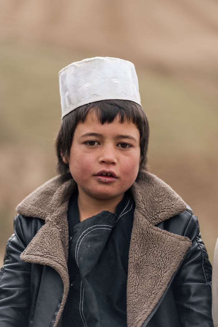 hero-homepage A young child wearing traditional Afghan attire, outdoors in Afghanistan.